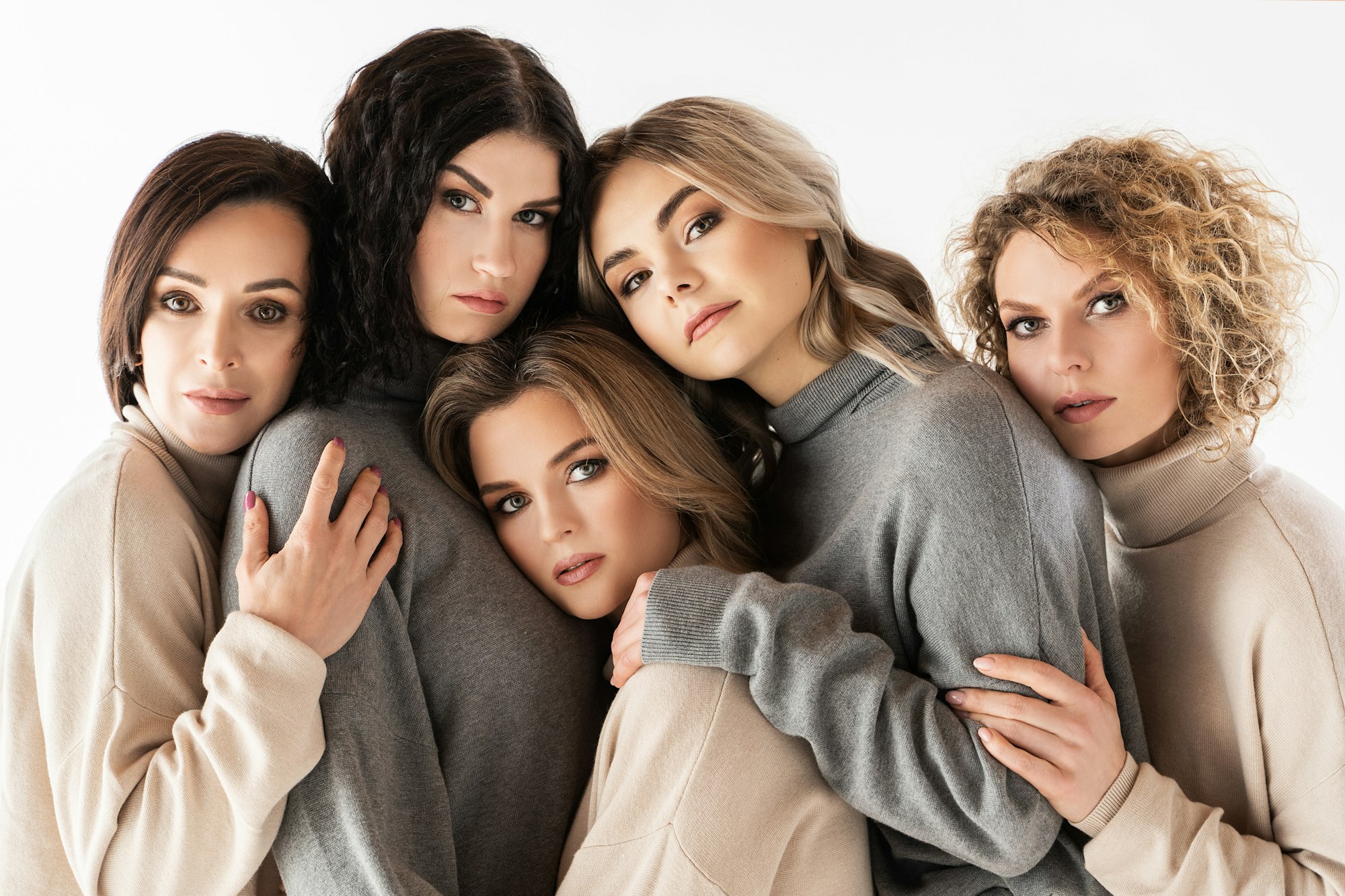 Group of different women wearing turtleneck jumpers on gray background